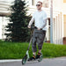 Man riding green teen adult kick scooter with one-step folding design outdoors