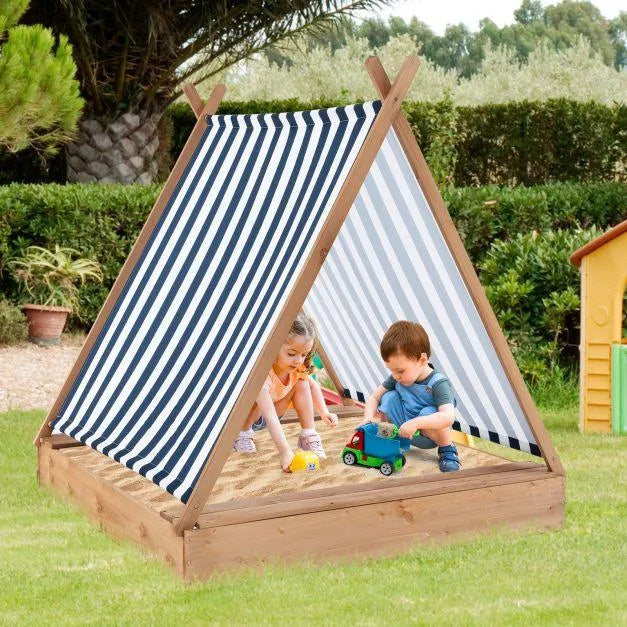 Kids playing in a wooden teepee sandbox with striped sun cover outdoors