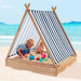 Kids playing in wooden teepee sandbox with striped sun cover on a sandy beach