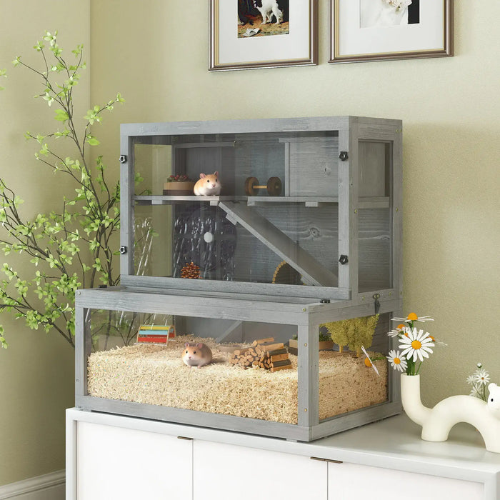 Three-tier grey wooden hamster cage with two hamsters, wheel, hut, and wood accessories on white cabinet