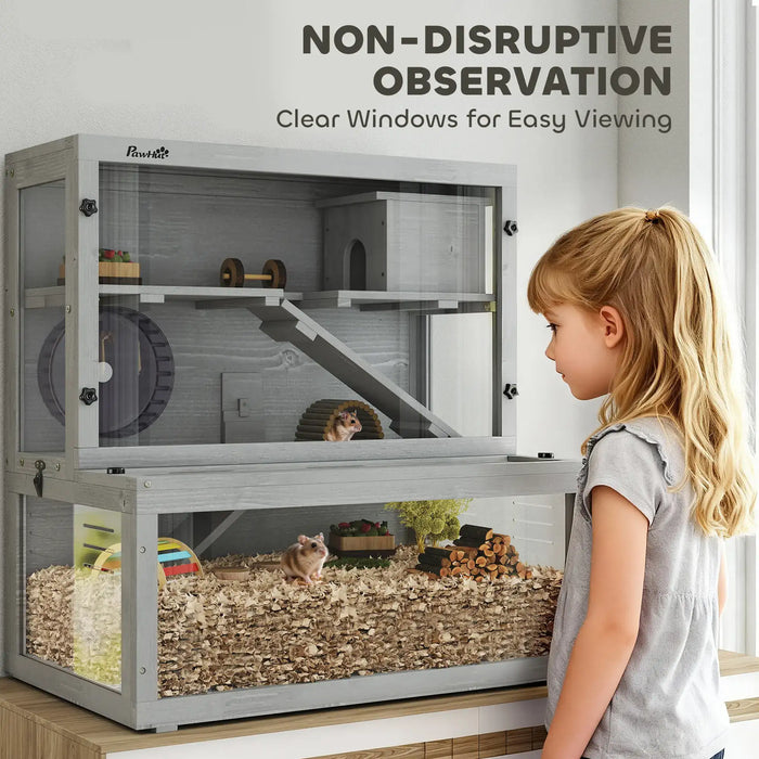 Three-tier grey wooden hamster cage with clear windows, accessories, and two hamsters observed by young girl