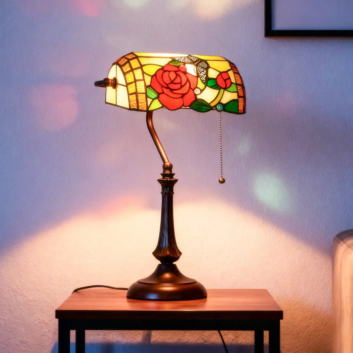 Stained glass lamp with floral design on a wooden table against a soft-focus background