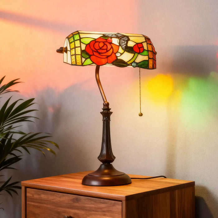 Decorative table lamp with stained glass shade on a wooden surface, soft focus background