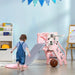Toddler with tiger-themed pink kids slide and basketball hoop in playroom