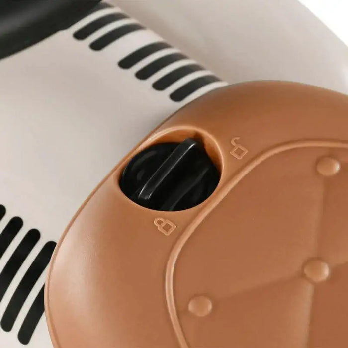 Close-up of toddler cream ride-on car lock mechanism with black switch and brown details