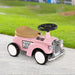 Pink toddler ride-on sliding car with steering wheel and vintage design on outdoor path