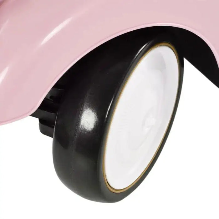 Close-up of a pink toddler ride-on car black and white wheel