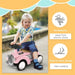 Toddler riding pink foot-to-floor sliding car with steering wheel outdoors, no batteries needed