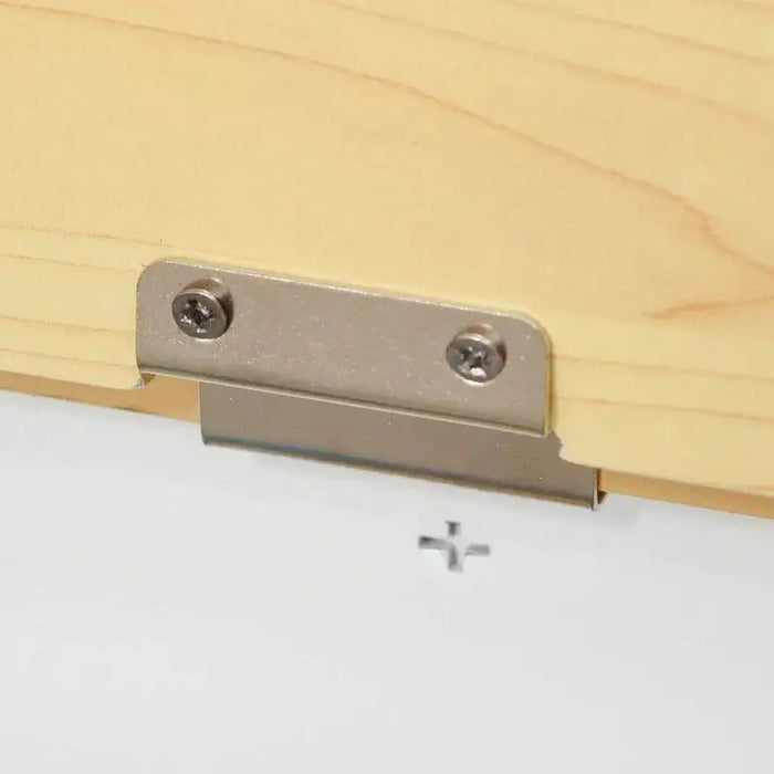 Close-up of a metal hinge attached to a light wood panel, part of toy storage box bench.