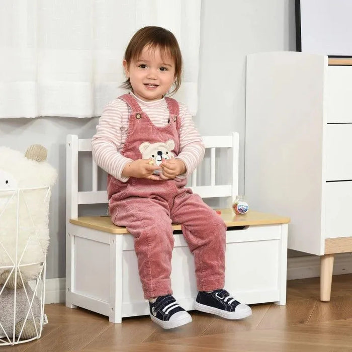 Toddler sitting on white toy storage bench with backrest in modern playroom