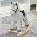 Grey and white striped plush rocking horse toy with wooden handles on a patterned rug.