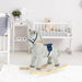 Grey and white striped plush rocking horse toy in a modern nursery with crib and decor