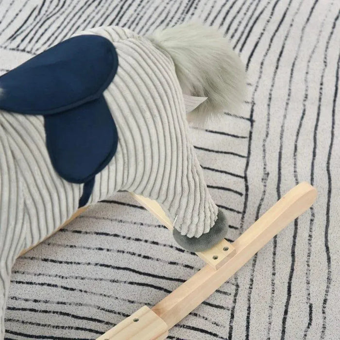 Grey and white striped plush rocking horse with wooden base on patterned rug