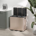 Beige trash bin with black lids in a kitchen setting