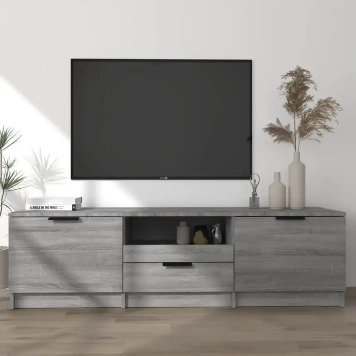 Modern living room with wall-mounted flat screen TV above gray wood TV stand featuring decorative vases and book