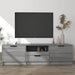 Modern living room with wall-mounted flat screen TV above gray wood TV stand featuring decorative vases and book