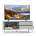 Light grey TV cabinet with two drawers, drop-down door, wooden decor boxes, vintage camera, and modern flat-screen TV