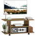 Walnut TV stand on wheels with open shelves holding books, vintage radio, lamp, and decor