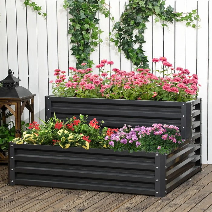 Two-tier dark grey galvanized steel raised garden bed with vibrant pink, red, and purple flowers on wooden deck