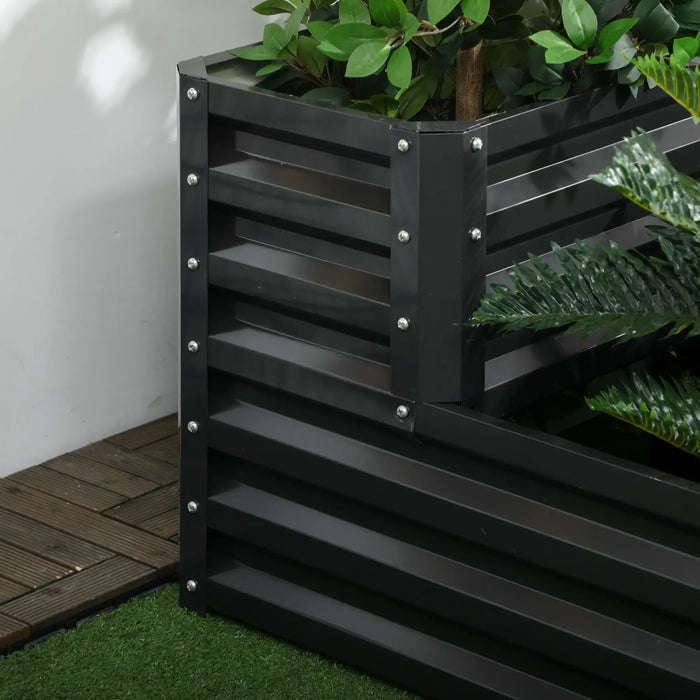 Two-tier dark grey galvanized steel raised garden bed with green plants on artificial grass and wooden flooring