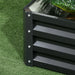Corner detail of dark grey galvanized steel two-tier raised garden bed on green artificial grass