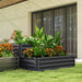 Two-tier galvanized steel raised garden bed with lush tropical and flowering plants in modern backyard