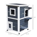 Two-tier grey wooden outdoor cat house with white trim, windows, door, and size dimensions