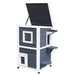 Two-tier grey outdoor wooden cat house with steps and hinged roof
