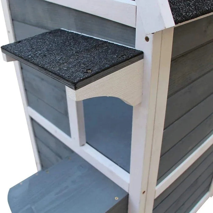 Two-tier outdoor wooden cat house in grey with black roof and white trim