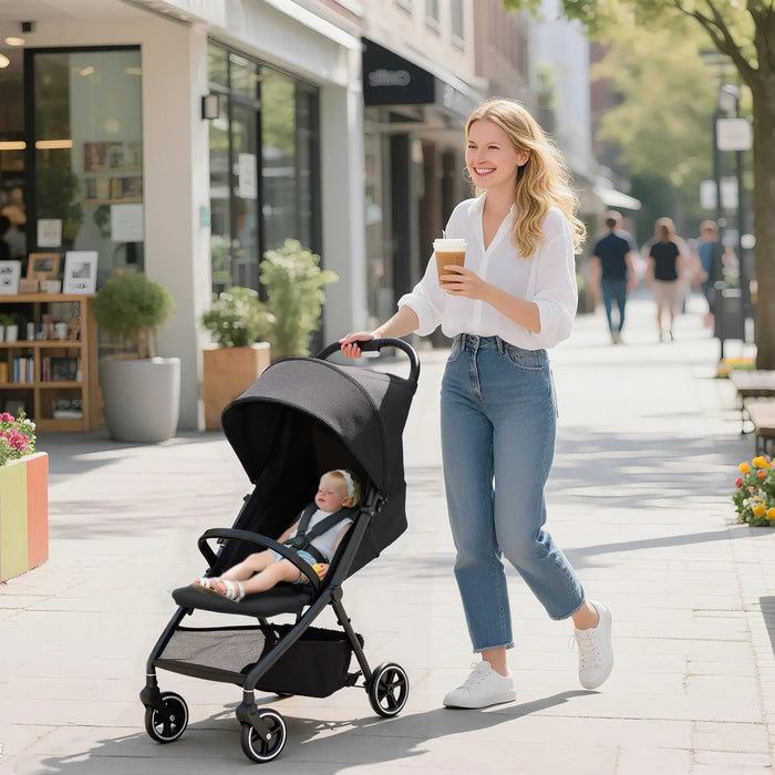 Woman pushing a stroller with a child in it, walking on a sidewalk.