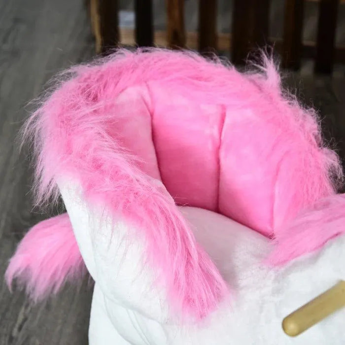 Plush unicorn rocker with white body, pink mane, and soft pink seat on wooden floor