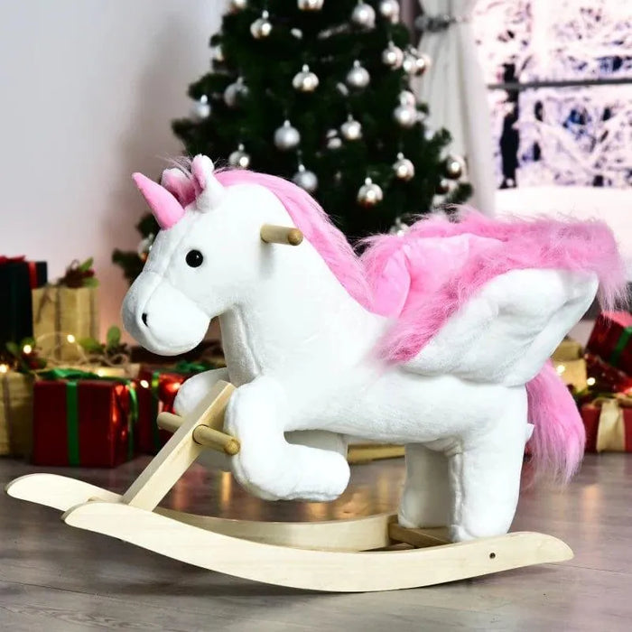 Plush white and pink unicorn rocker toy for kids by a Christmas tree and presents
