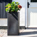 Urban black double-walled flower pot with hydrangeas by a modern home entrance