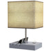Table lamp with a beige square shade and a gray base on a white background