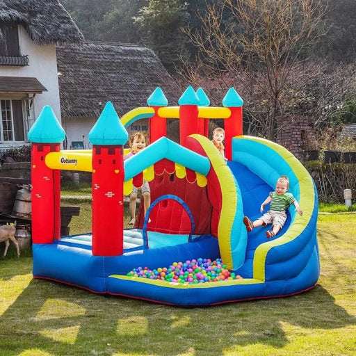 Kids playing on colorful inflatable bouncy castle with slide, ball pit, and climbing wall outdoors