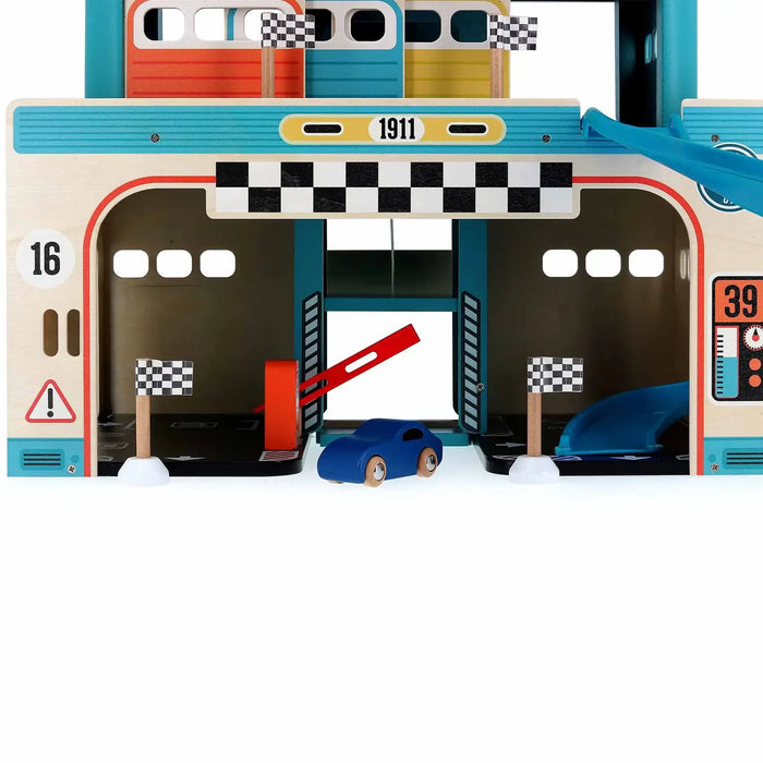 Vintage wooden toy garage with spiral ramp, blue toy car, checkered flags, and race track details