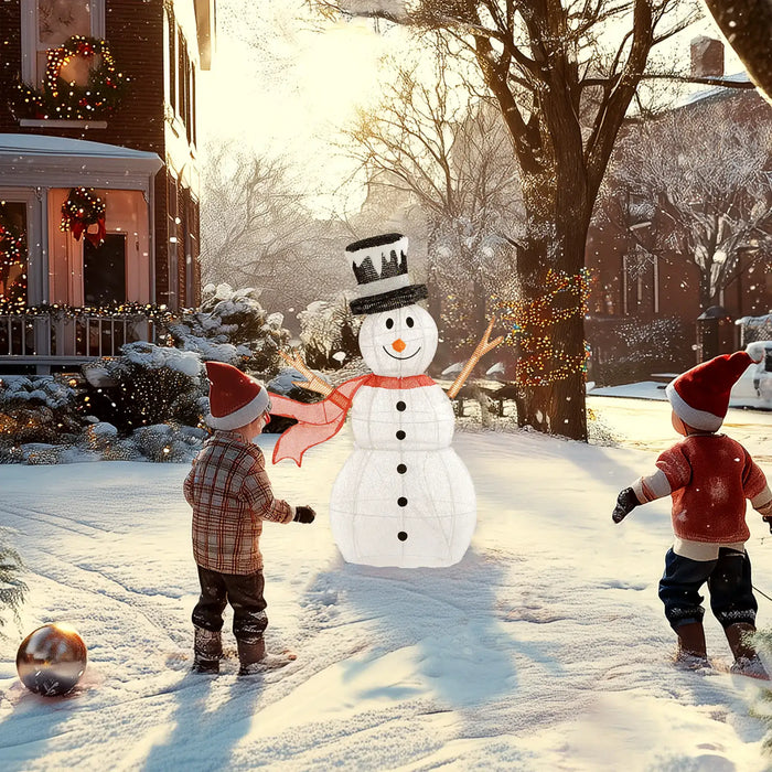 Two children in Santa hats playing in snow near a snowman with a red scarf and black top hat
