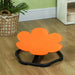 Orange flower-shaped chair on a wooden floor with a plant and basket in the background.