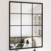 Black-framed mirror with grid design reflecting a living room.