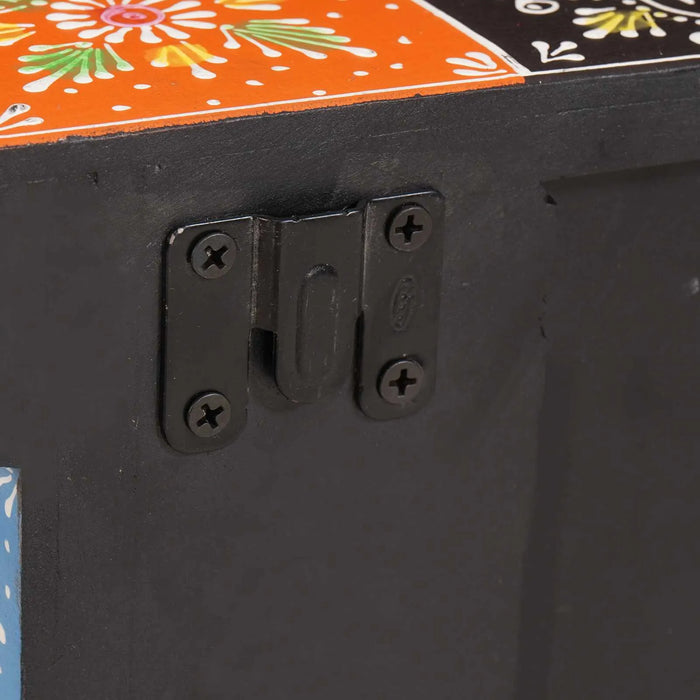 Close-up of black metal latch on colorful painted wooden toy box with floral and geometric designs