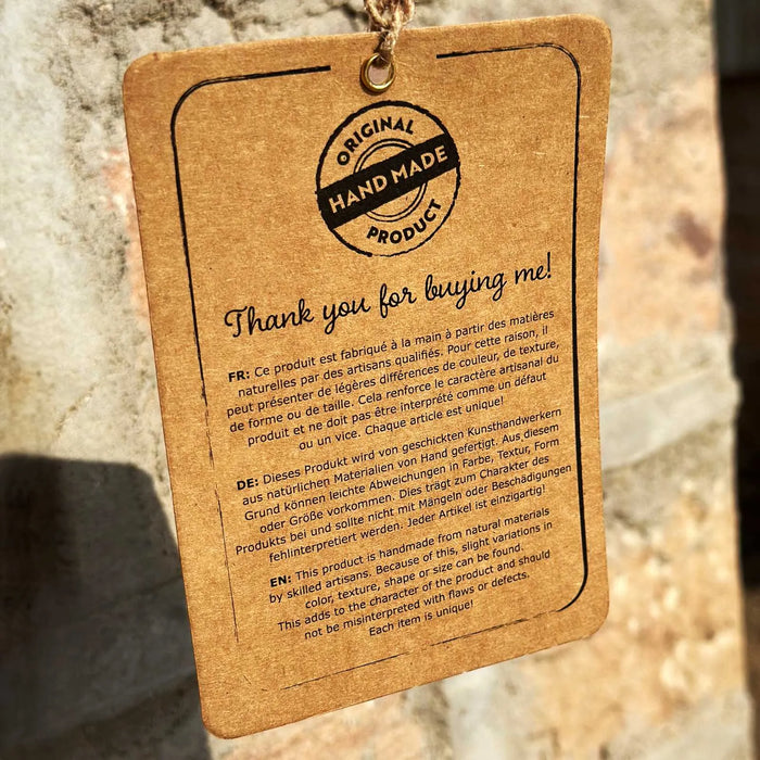 Handmade product tag with thank you message and details in English, French, and German on brown paper
