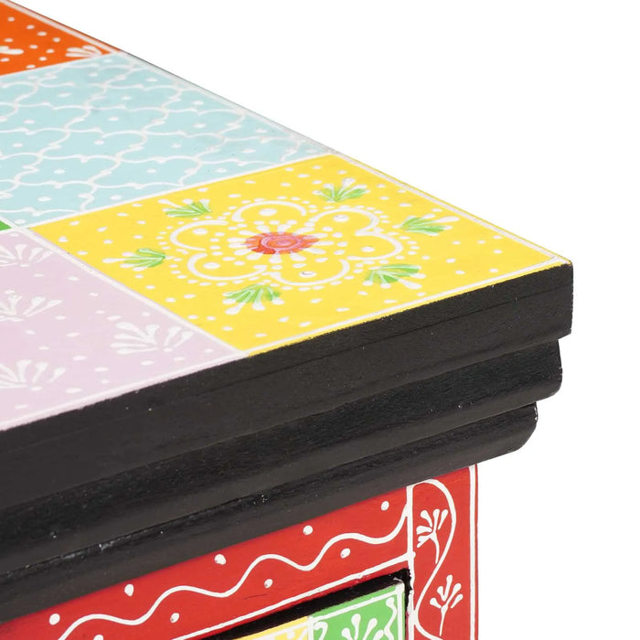 Colorful wooden toy box corner with hand-painted floral patterns on yellow, blue, orange, pink, and red panels