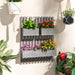 Wall-mounted grey wooden planter with three boxes holding vibrant flowers in bright indoor garden setting