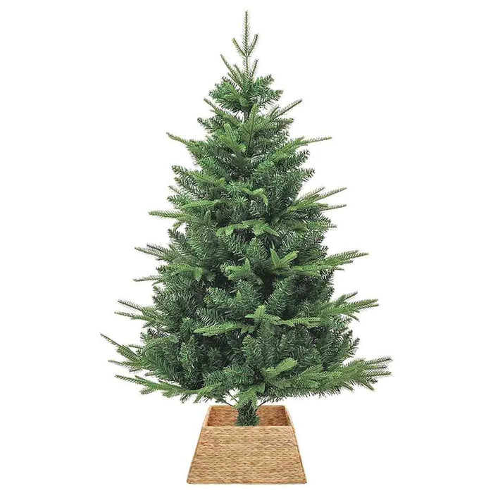 Artificial green Christmas tree in natural woven basket stand on white background