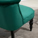 Green upholstered chair with black legs on a patterned carpet