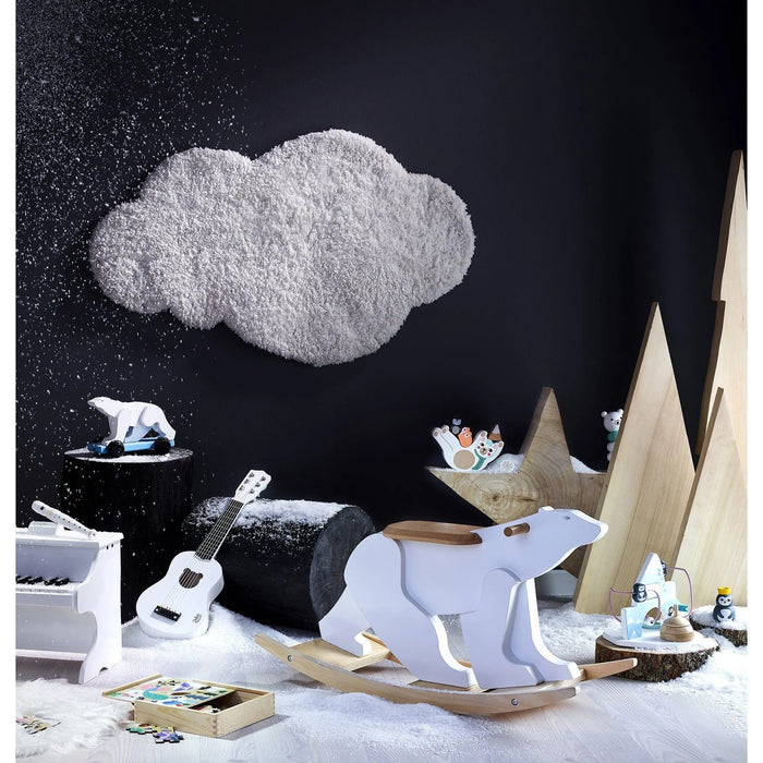 Wooden baby rocking polar bear in snowy arctic-themed nursery with toys and decor