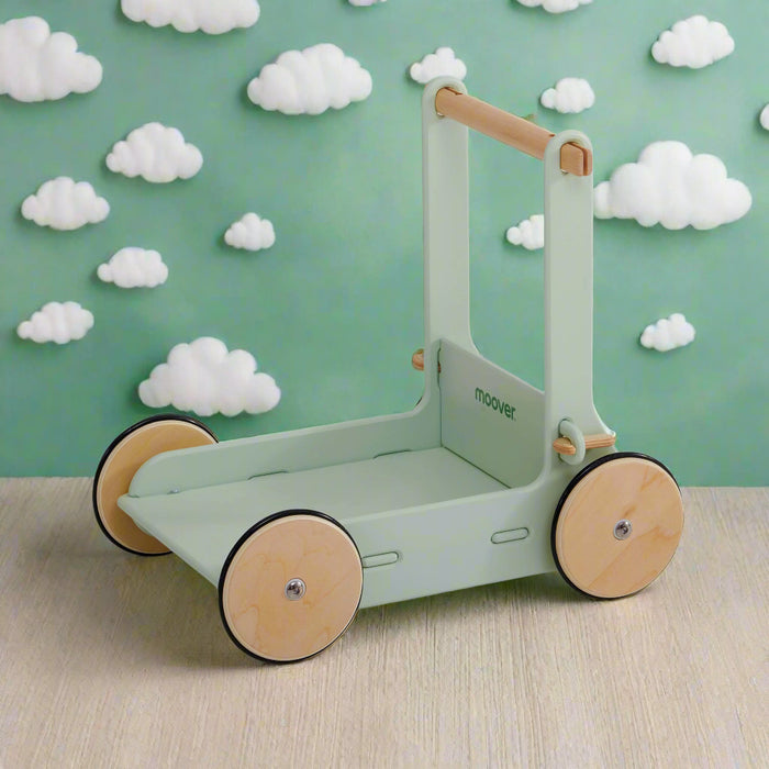 Eco-friendly wooden baby walker in pastel green with natural wheels on wood surface