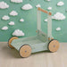 Eco-friendly wooden baby walker in pastel green with natural wheels on wood surface