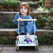 Toddler with wooden baby walker and eggs outdoors on stone steps, eco-friendly design