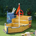 Wooden boat sandbox with red steering wheel, nautical flag, bench, and storage on artificial grass.